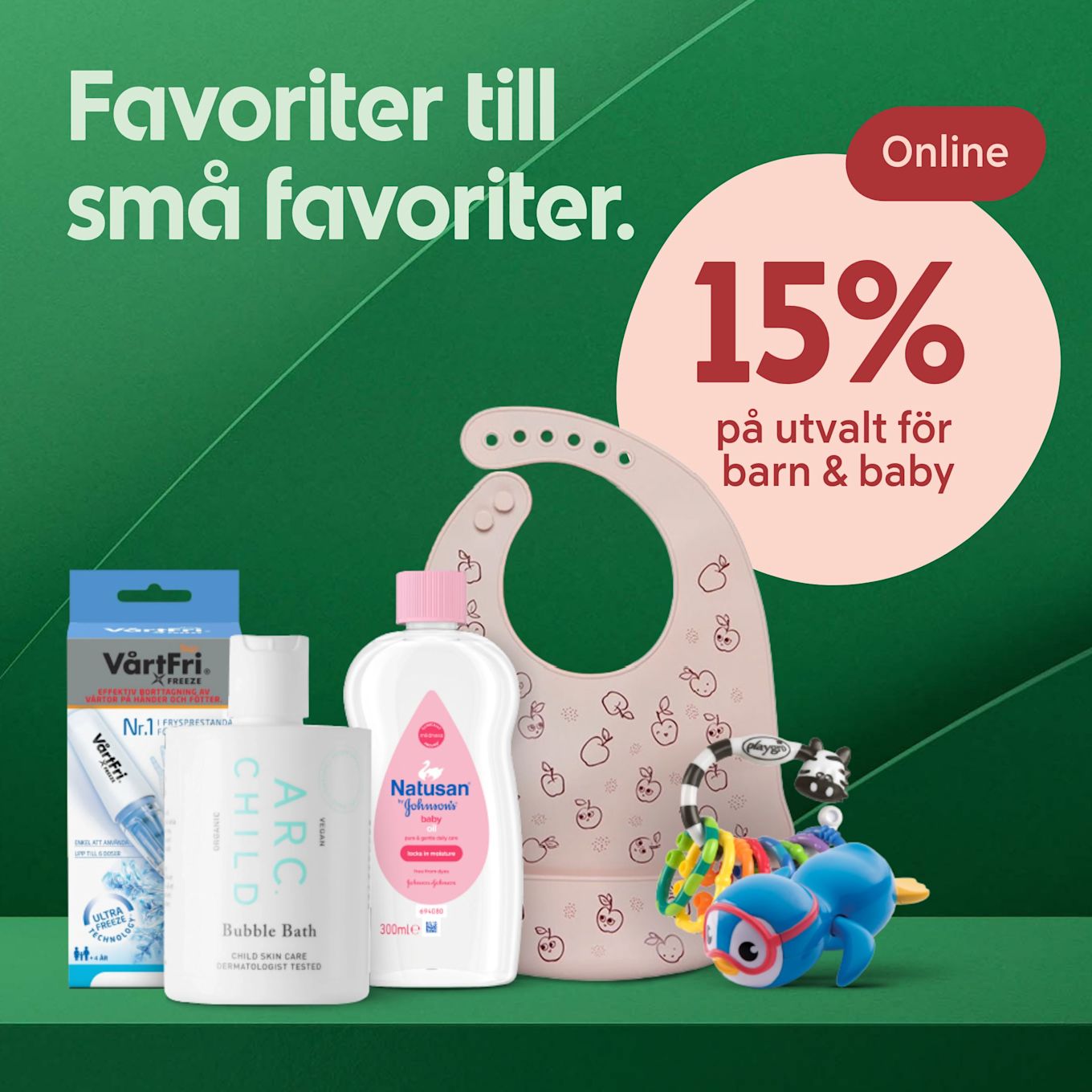 Olika barnprodukter som barnolja, badskum, en plastkrage, en napp och en leksak ligger mot en grön bakgrund med text om 15% rabatt online på utvalt för barn och baby.