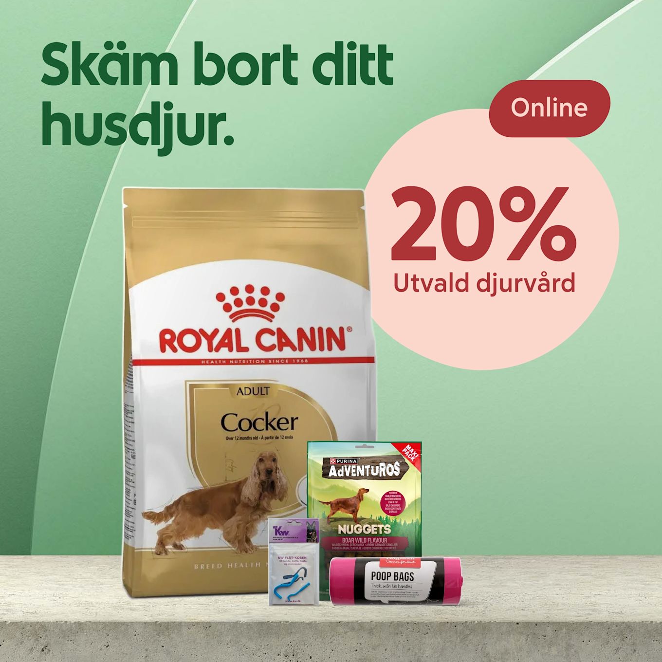 Stort paket Royal Canin hundfoder med en cocker spaniel på förpackningen, omgiven av mindre hundtillbehör som godispåse, bajspåsar och platt-koppel, mot grön bakgrund med texten "Skäm bort ditt husdjur" och en rosa cirkel med "20%".