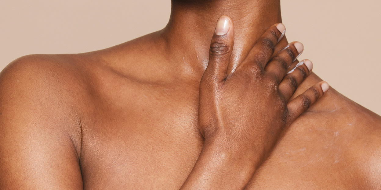 Kvinna smörjer in dekolletaget med hudkräm.