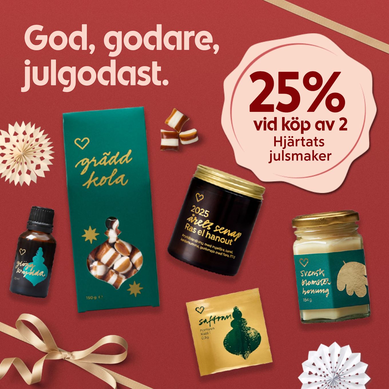 Julprodukter som gräddkola, glögg krydda, saffran, senap och honung visas på röd bakgrund med text om 25% rabatt vid köp av två Hjärtats julsmaker.