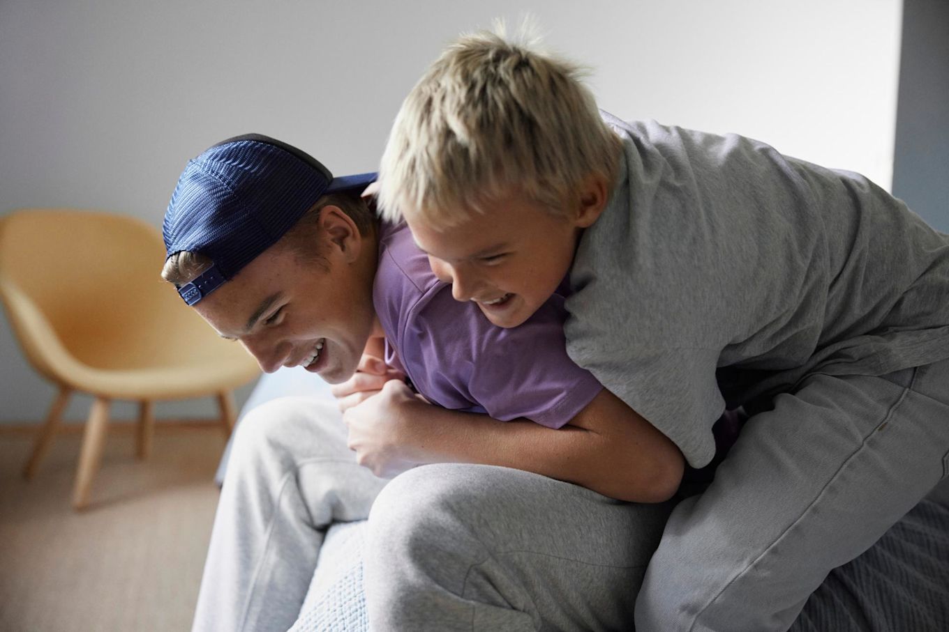 Två tonårsbröder som skojbråkar med varandra och skrattar.