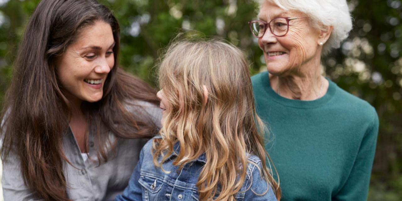 Tre generationer av kvinnor sitter tillsammans.