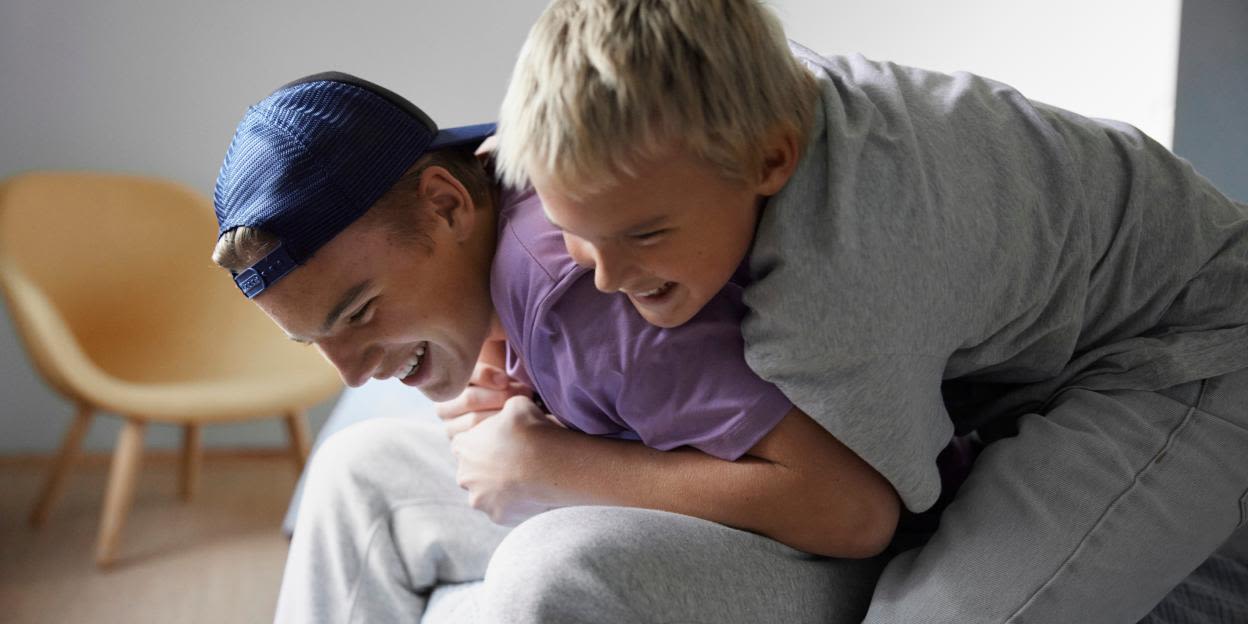 Två tonåringar leker och busar tillsammans inomhus. Bilden illustrerar tonårstiden och hur kroppen förändras under puberteten, då svettning och behovet av god hygien ofta ökar.