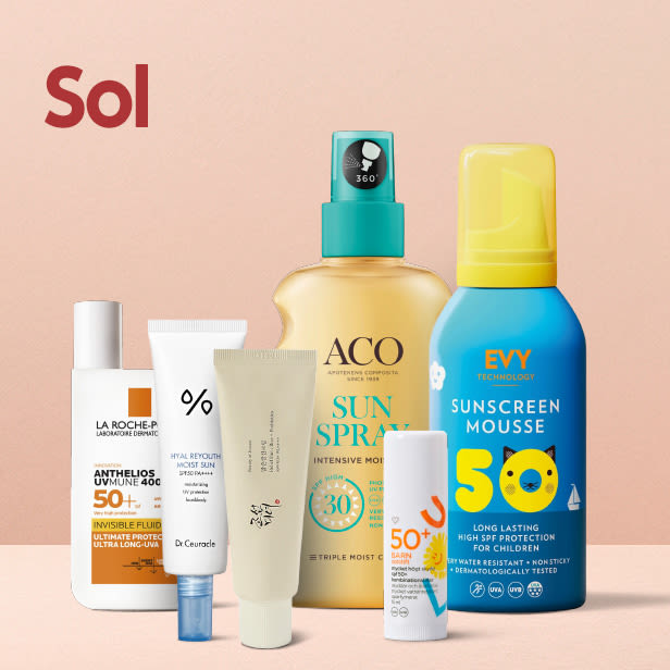 Fem olika solskyddsprodukter i olika förpackningar står uppställda mot en ljusrosa bakgrund.