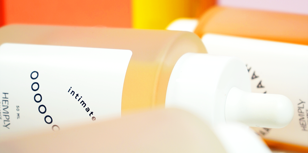 Närbild på en flaska med intimvårdsprodukt från Hemply. Flaskan har en ljus och minimalistisk design med en vit etikett och en pipett. 