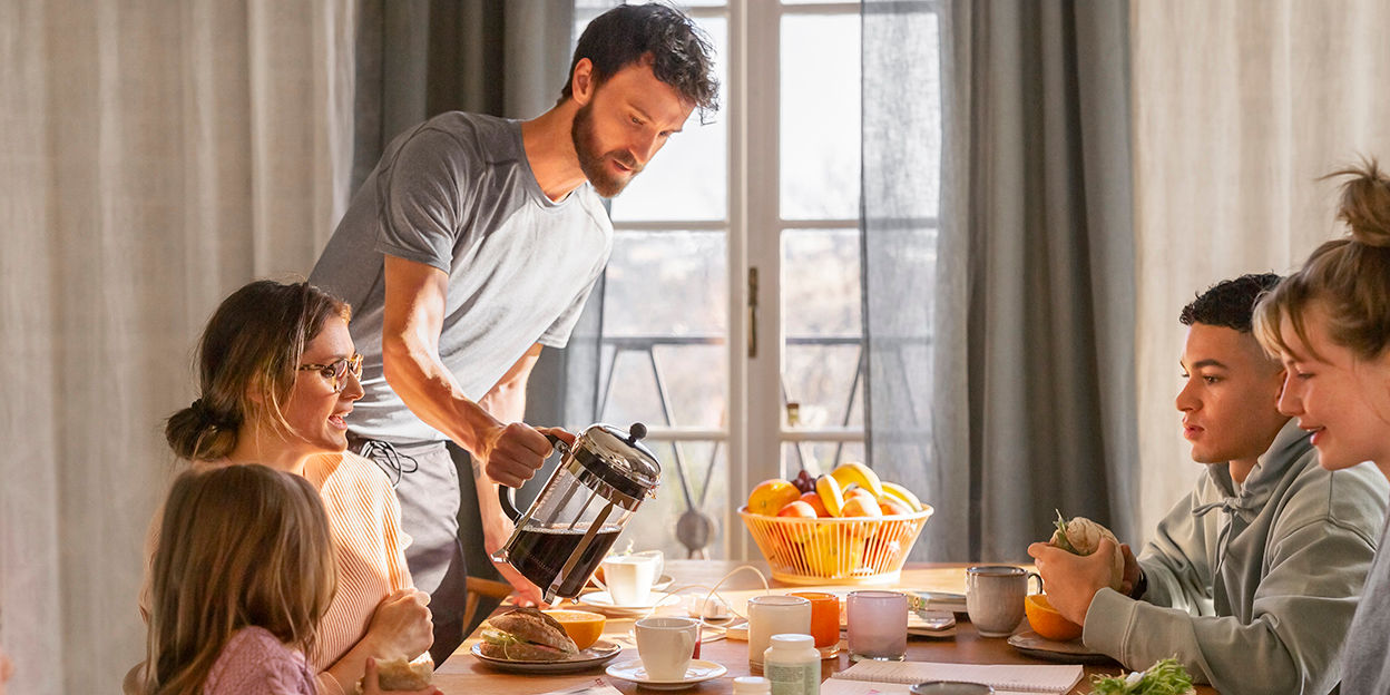 Ett väldukat frukostbord där familjen sitter samlad